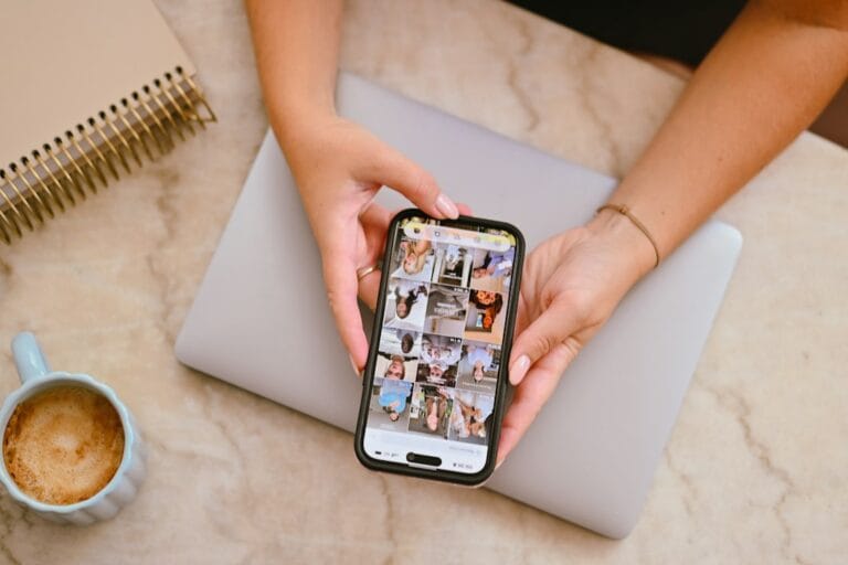 Business owner checking social media feed on smartphone while planning Facebook ads for lead generation