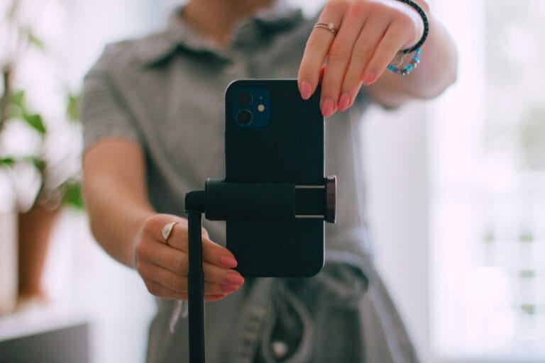 Woman recording a vertical video on her phone in the right Instagram Reels video format